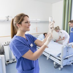 PflegekrÃ¤fte versorgen eine Patientin in einem Krankenzimmer