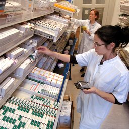 Pharmazeutische Angestellte sortiert Medikamente in FÃ¤cher