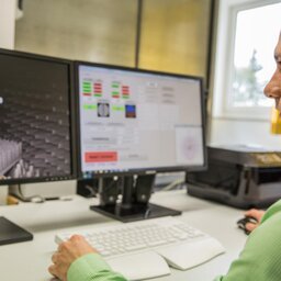 Mann sitzt vor zwei Monitoren und arbeit an einer digitalen Zeichnung
