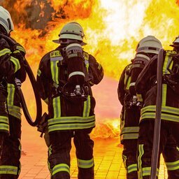 Vier Feuerwehrleute mit AtemschutzgerÃ¤ten lÃ¶schen einen Brand