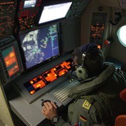 Soldat vor einem Radarmonitor im Flugzeug.