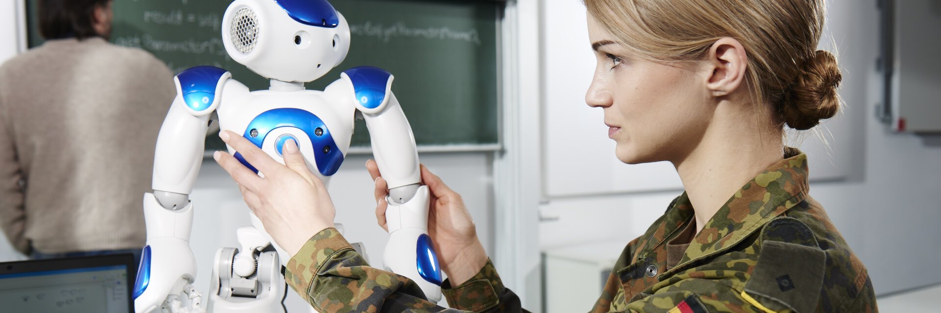 IT-Softwareentwicklerin in Uniform arbeitet an einem kleinen Roboter der UniversitÃ¤t der Bundeswehr