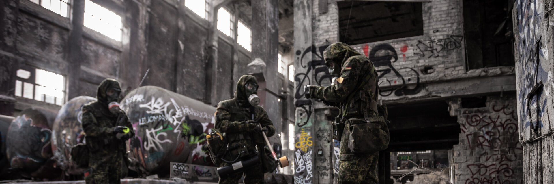 Soldaten der ABC Abwehrtruppe mit Schutzmasken untersuchen eine Lagerhalle auf Kampfstoffe.