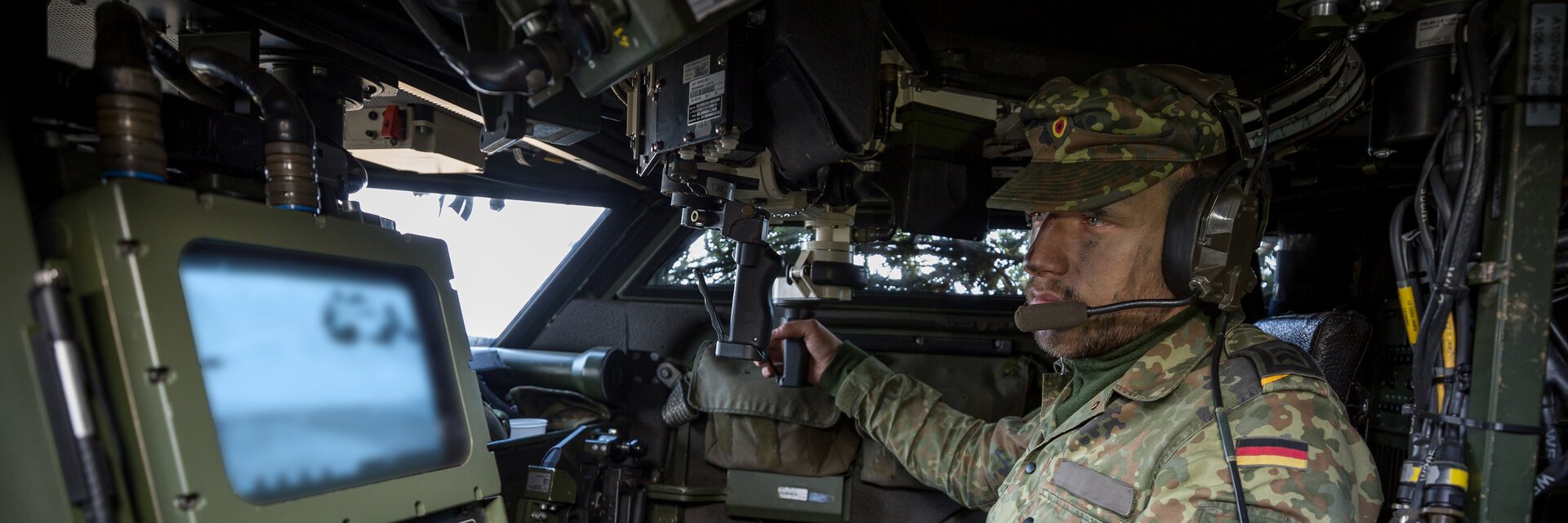 Ein Soldat der HeeresaufklÃ¤rungstruppe sitzt in einem gepanzerten Fahrzeug und bedient technisches GerÃ¤t.
