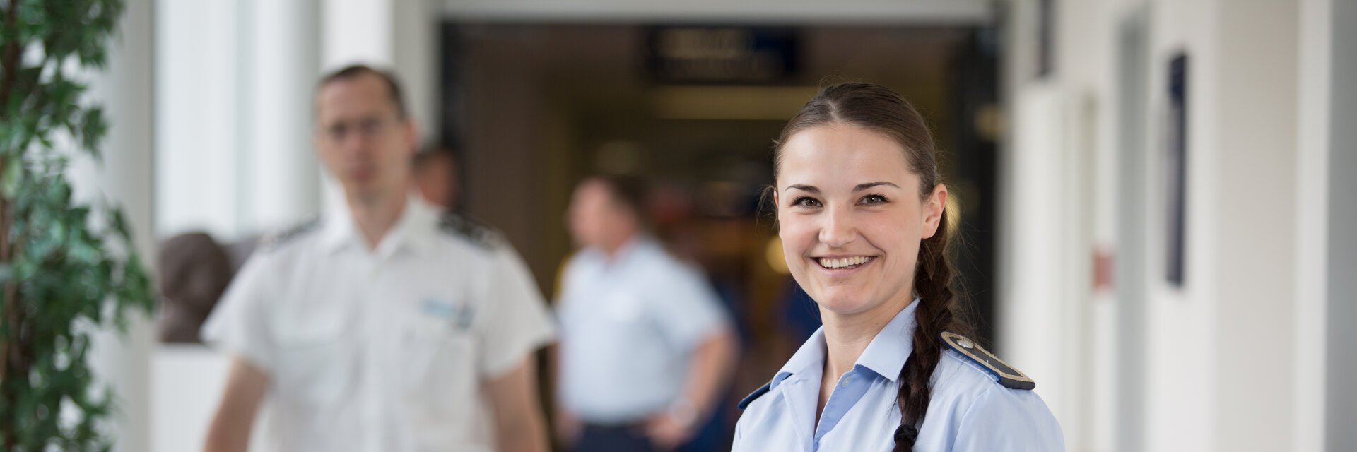 Personalsachbearbeiterin in Uniform steht mit Unterlagen in den HÃ¤nden in einem Flur des Bundeswehrkrankenhauses.