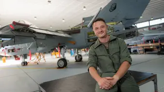 Ein Fluggerätmechaniker sitzt vor einem Kampfjet der Bundeswehr