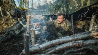 Ein Soldat verpflegt im Biwak