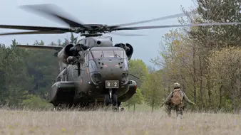 Ein Hubschrauber im Landeanflug auf einem Feld