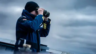 Ein Soldat der Marine schaut durch ein Fernglas