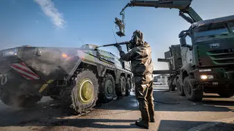 Ein Soldat wäscht ein Fahrzeug der Bw