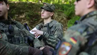 Soldatinnen und Soldaten der Bundeswehr stehen in einem Waldstück