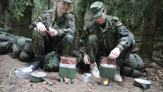 Kameraden im Biwak bereiten Essen vor