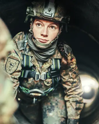 Eine Soldatin in Schutzausrüstung und mit Helm
