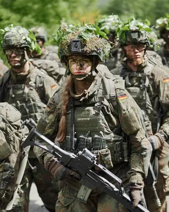 Eine Soldatin in Tarnkleidung in einer Gruppe mit anderen Soldaten
