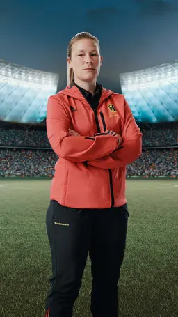 Sarah steht auf einem Spielfeld im Fussballstadion