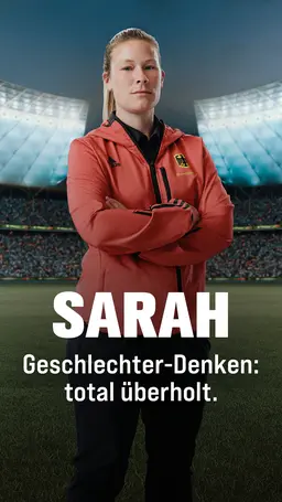 Sarah steht auf einem Spielfeld im Fussballstadion