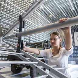 Ingenieurin bei der Arbeit an einer Aluminiumantenne in der ein Halle