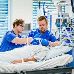 Zwei Fachkrankenpfleger betreuen einen Patienten