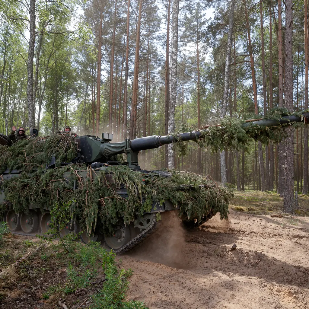Panzerhaubitze mit Ästen getarnt in einer Waldstellung