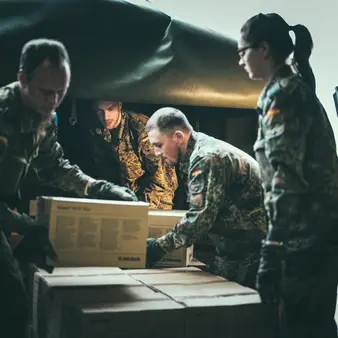 Mehrere Soldaten sind dabei, Pakete zu verladen