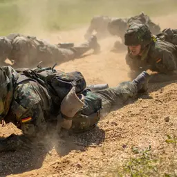 Jugendliche kriechen auf einem Feldweg über den Boden