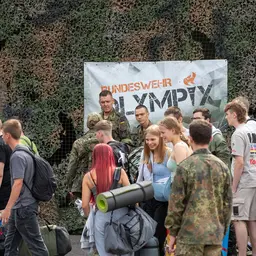 Teilnehmer Bw Olympix vor einem Tarnnetz