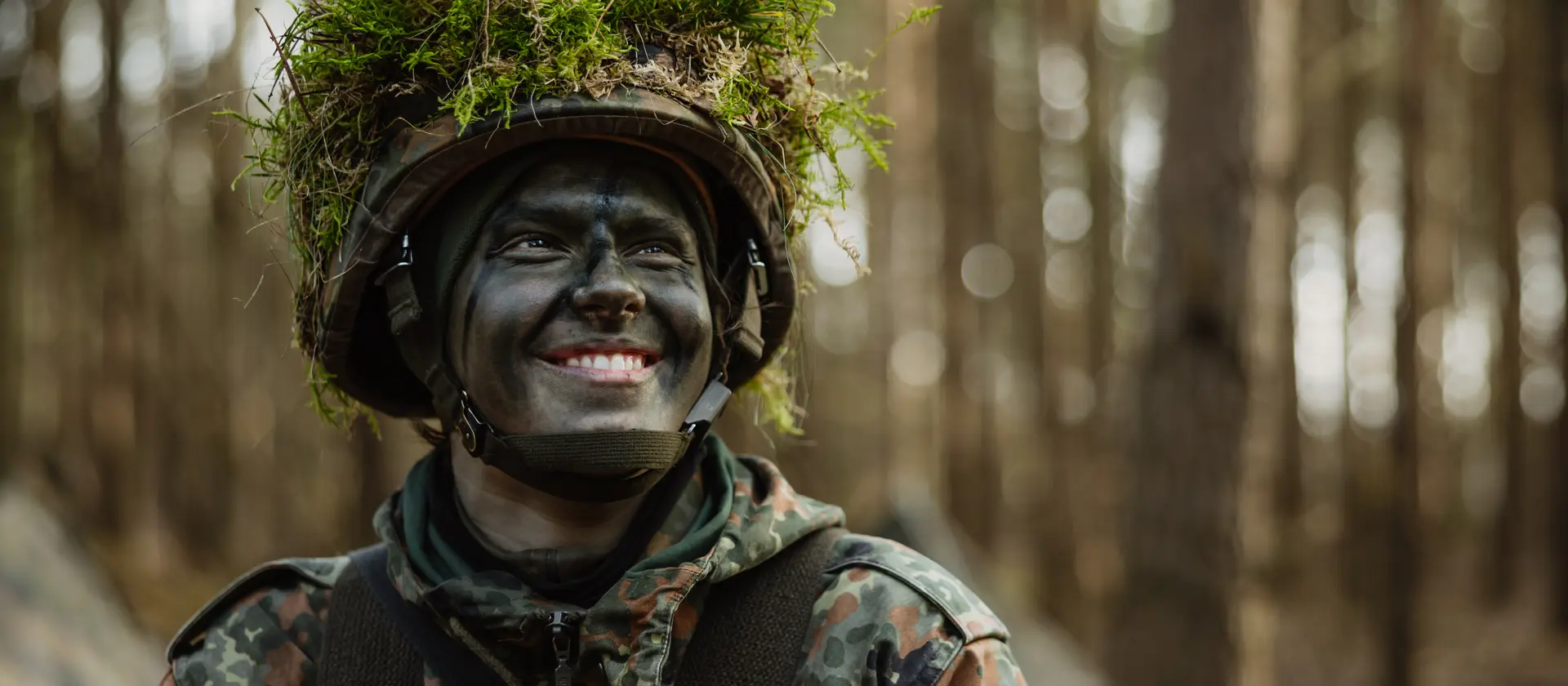 Ein getarnter Soldat der Bundeswehr im Wald