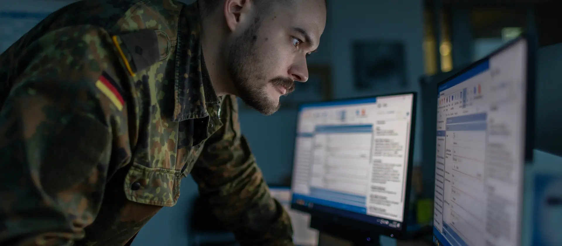 Ein Soldat der Bundeswehr steht vor mehreren Monitoren
