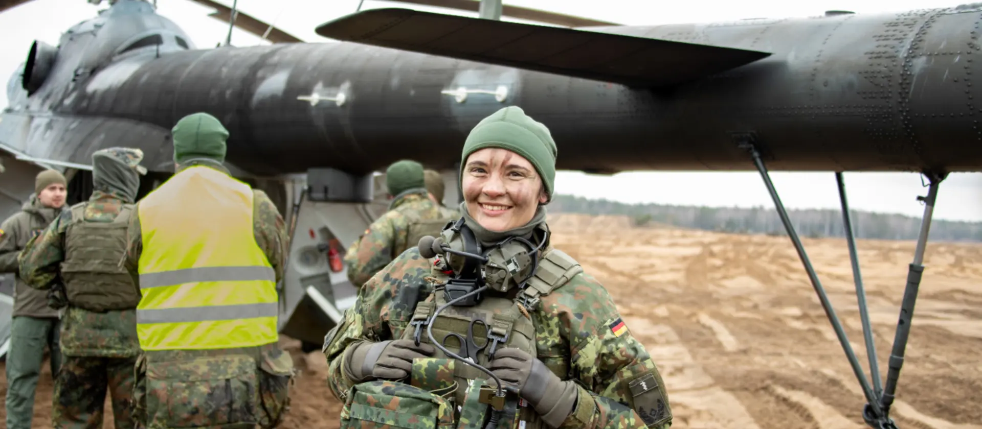 Eine Soldatin der Bundeswehr steht vor einem Hubschrauber