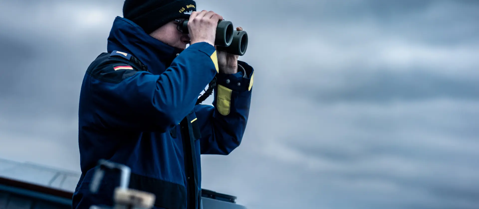 Ein Soldat der Marine schaut durch ein Fernglas