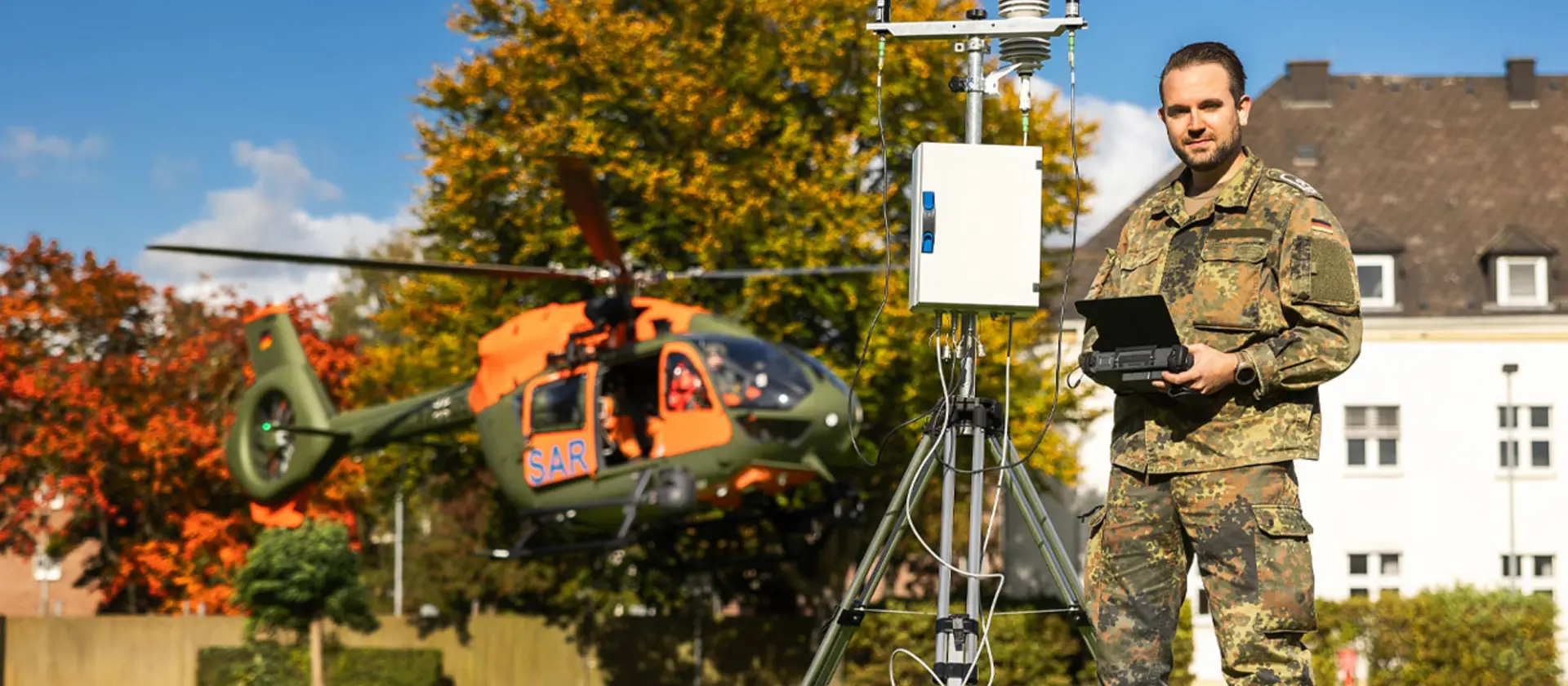Ein Soldat der Bundeswehr steht vor einem Hubschrauber