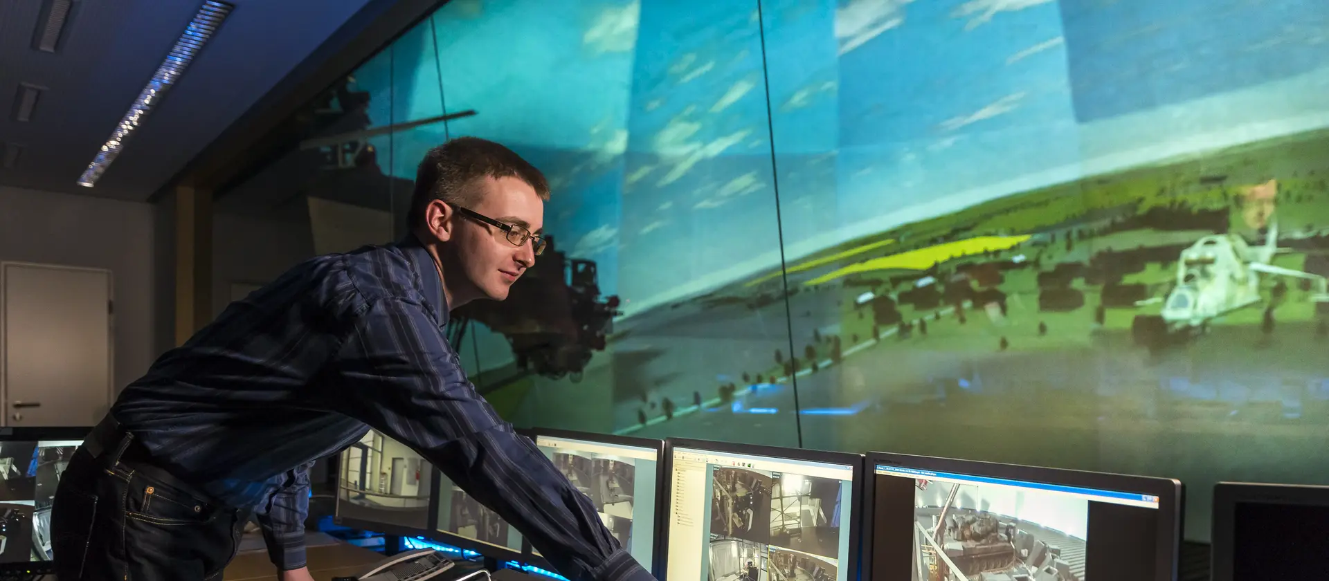 Mann vor Überwachungsmonitoren eines Flugsimulators