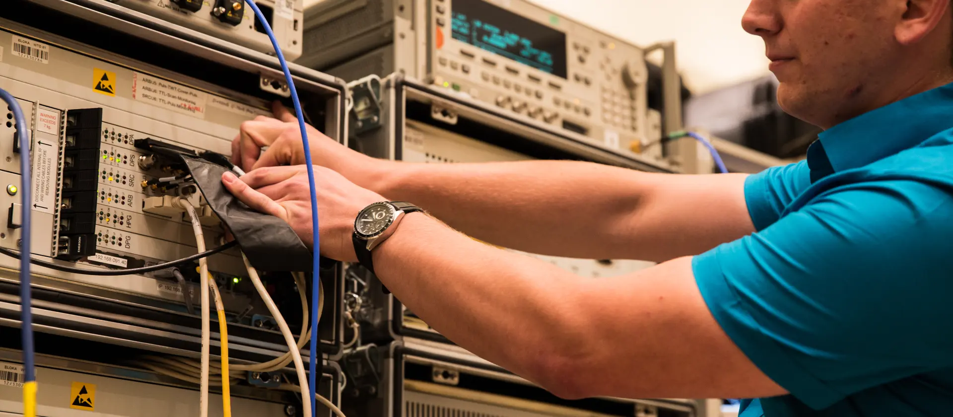 Mann überprüft die Verkabelung technischer Geräte