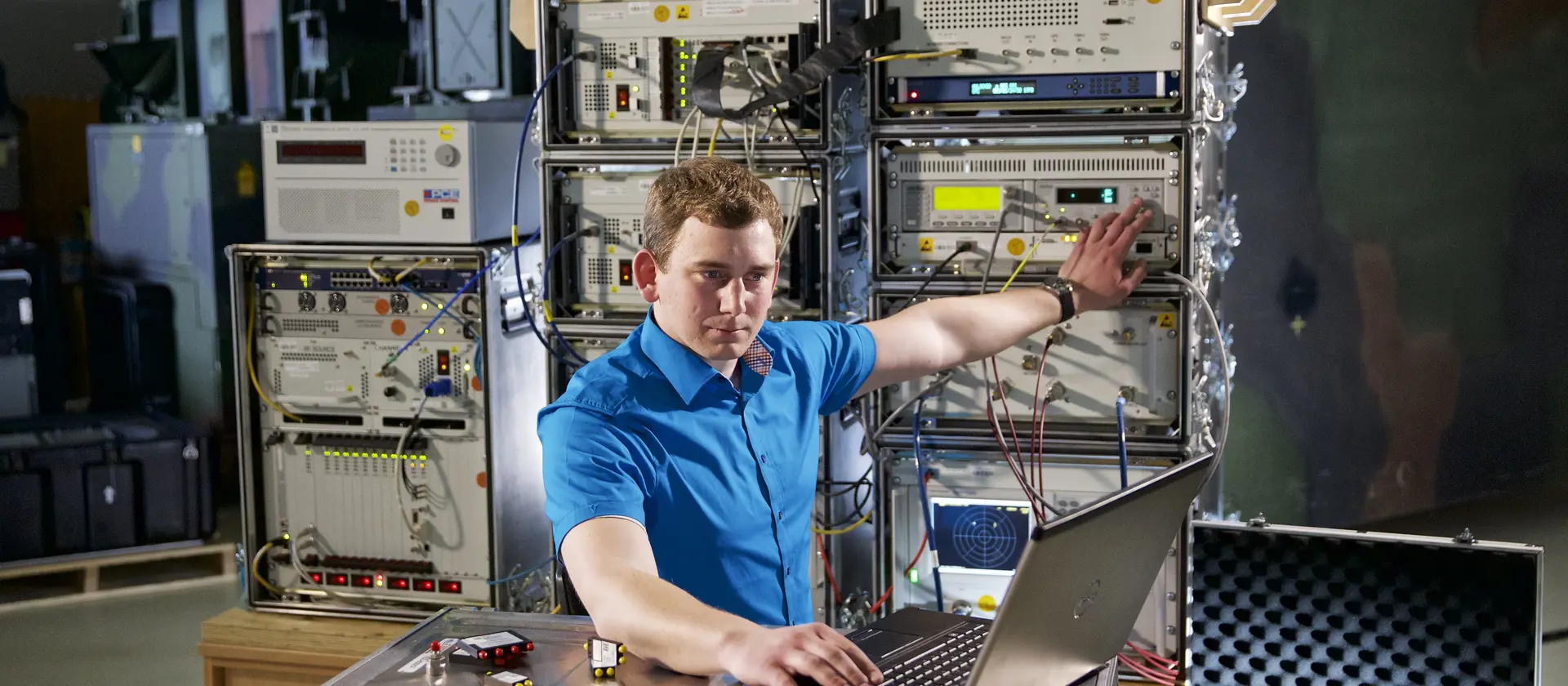 Mann überprüft elektronische Geräte mit einem Laptop