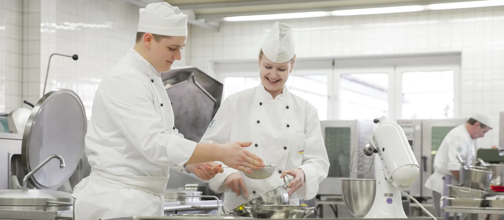 Koch und Köchin bereiten in der Küche Essen zu
