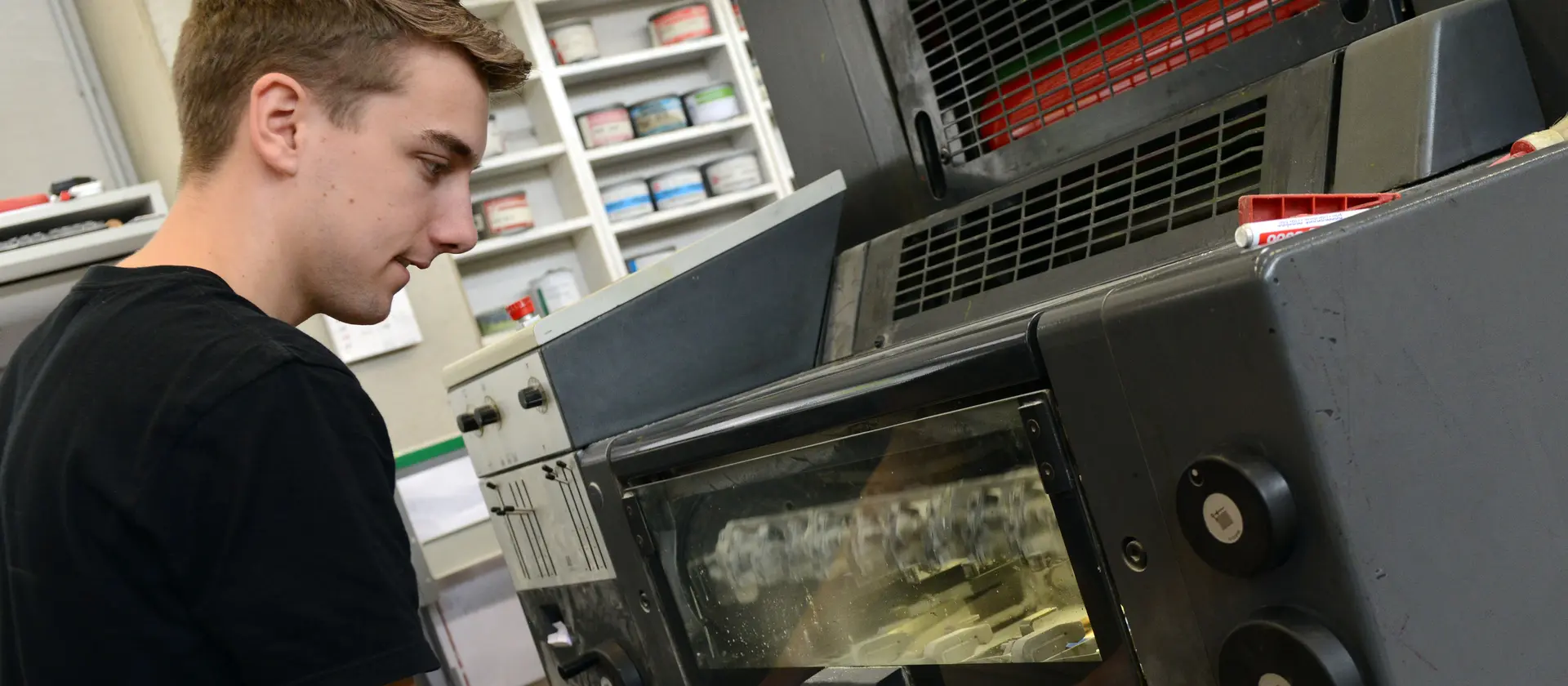 Medientechnologe bei der Arbeit an einem großen Drucker