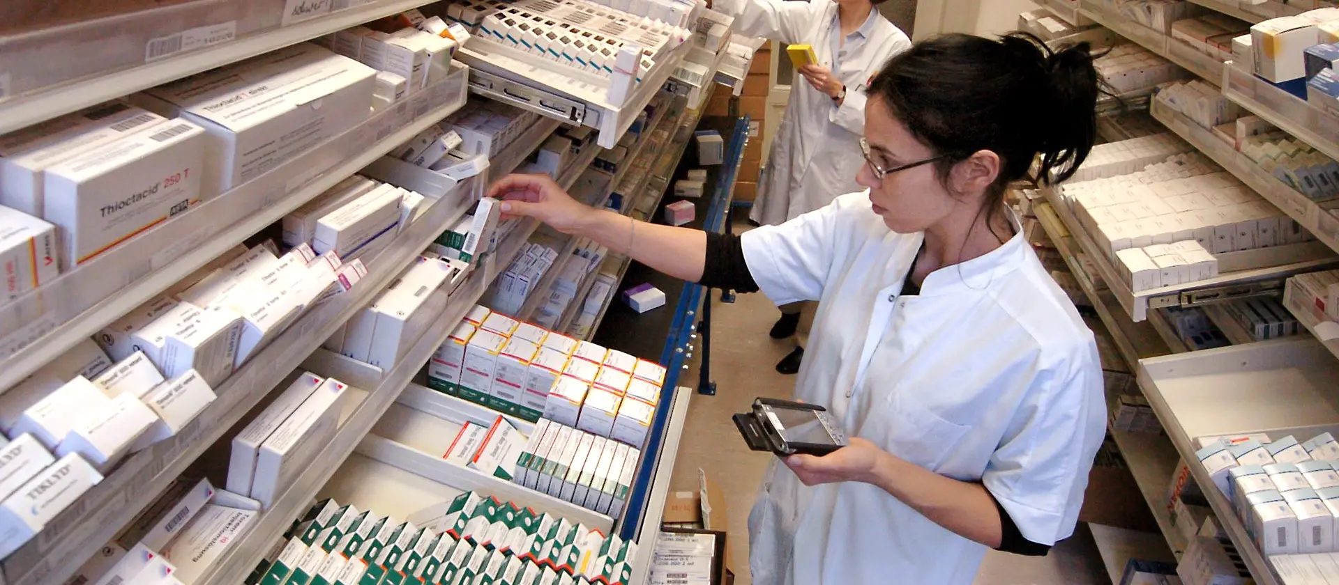 Pharmazeutische Angestellte sortiert Medikamente in Fächer