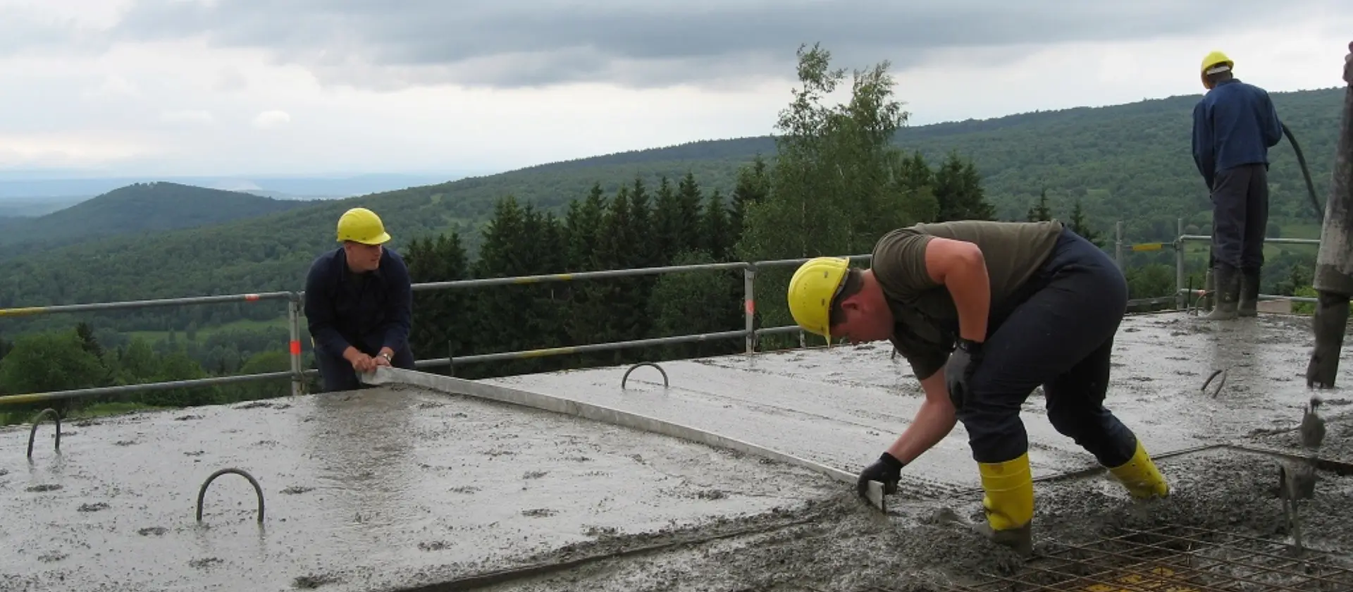 Beton und Stahlbetonbauer glätten den frischen Beton auf einer Baustelle