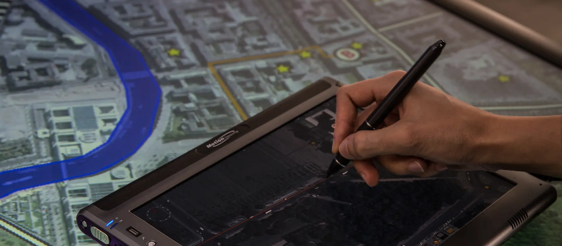 Hand mit elektronischem Pen, die ein Tablet bedient und etwas zeichnet