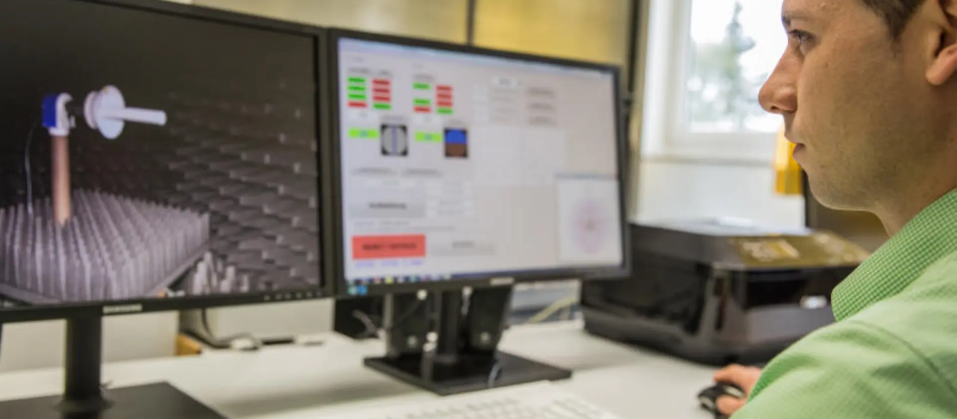 Mann sitzt vor zwei Monitoren und arbeit an einer digitalen Zeichnung