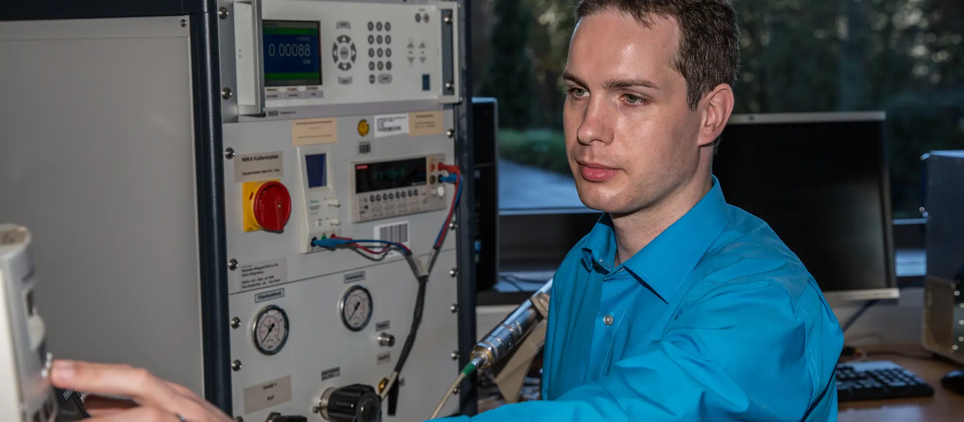 Ingenieur mit blauem Hemd arbeitet an einem technischen Gerät