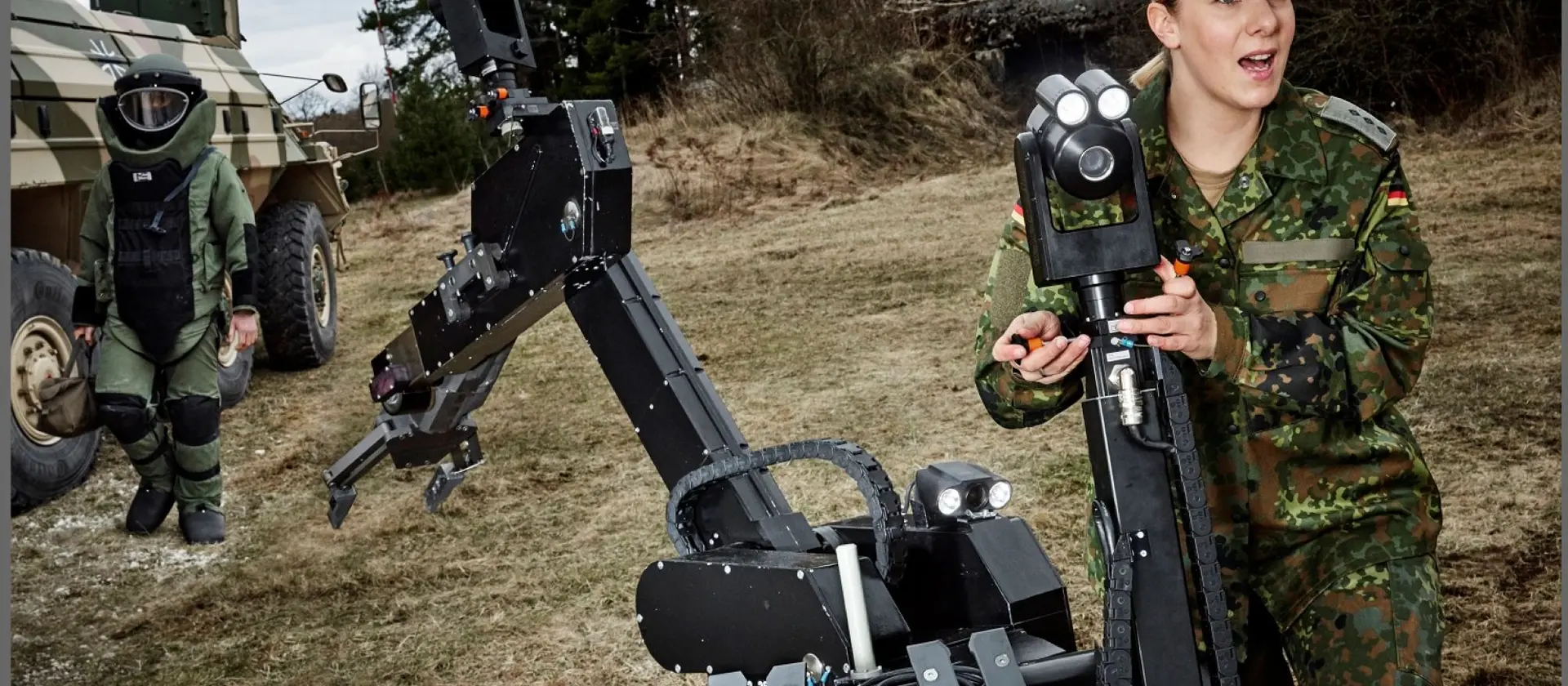 Soldatin des Kampfmittelabwehrdienstes arbeitet im Gelände an einem technischen Gerät