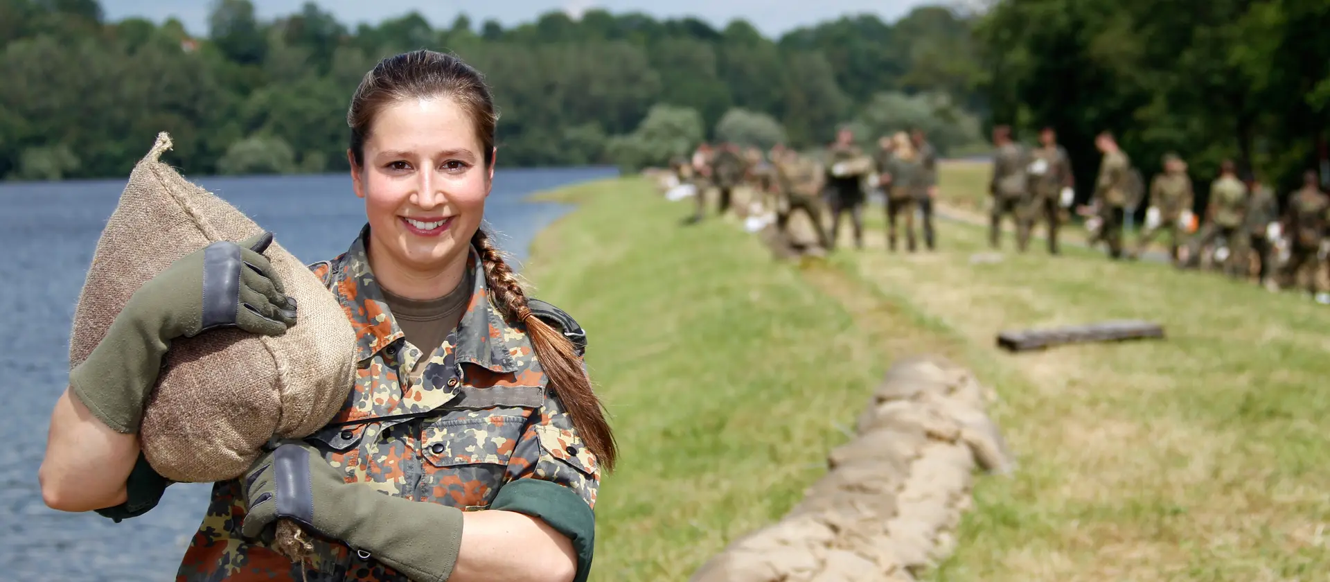 Eine Soldatin der Bundeswehr während der Hochwasser Einsatzes steht an einem See