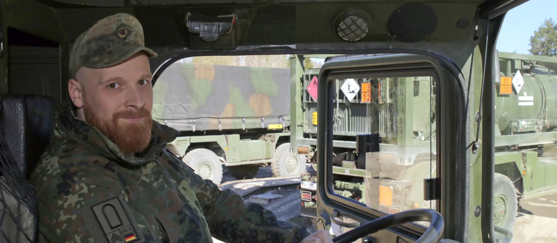 Ein Soldat und Kraftfahrer sitzt am Steuer eines Bundeswehrfahrzeugs