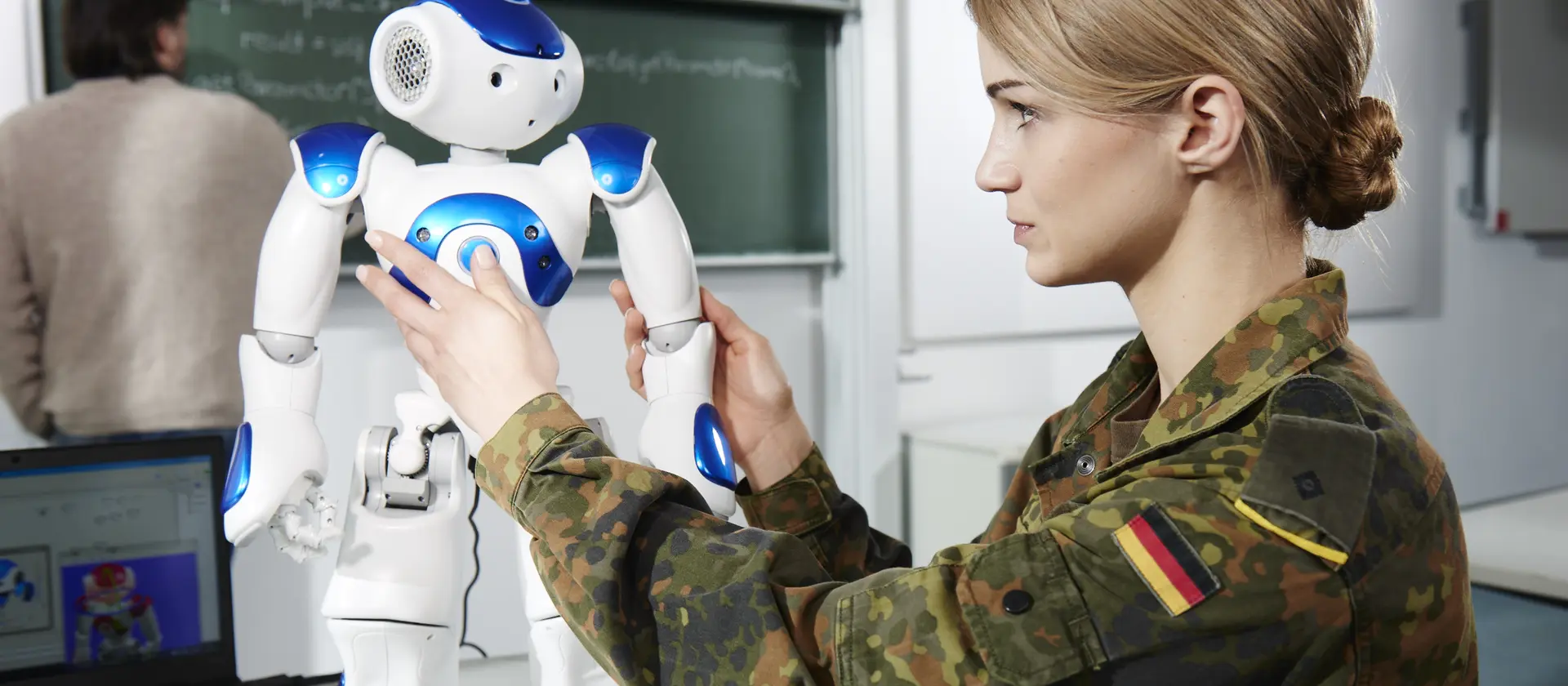 IT-Softwareentwicklerin in Uniform arbeitet an einem kleinen Roboter der Universität der Bundeswehr