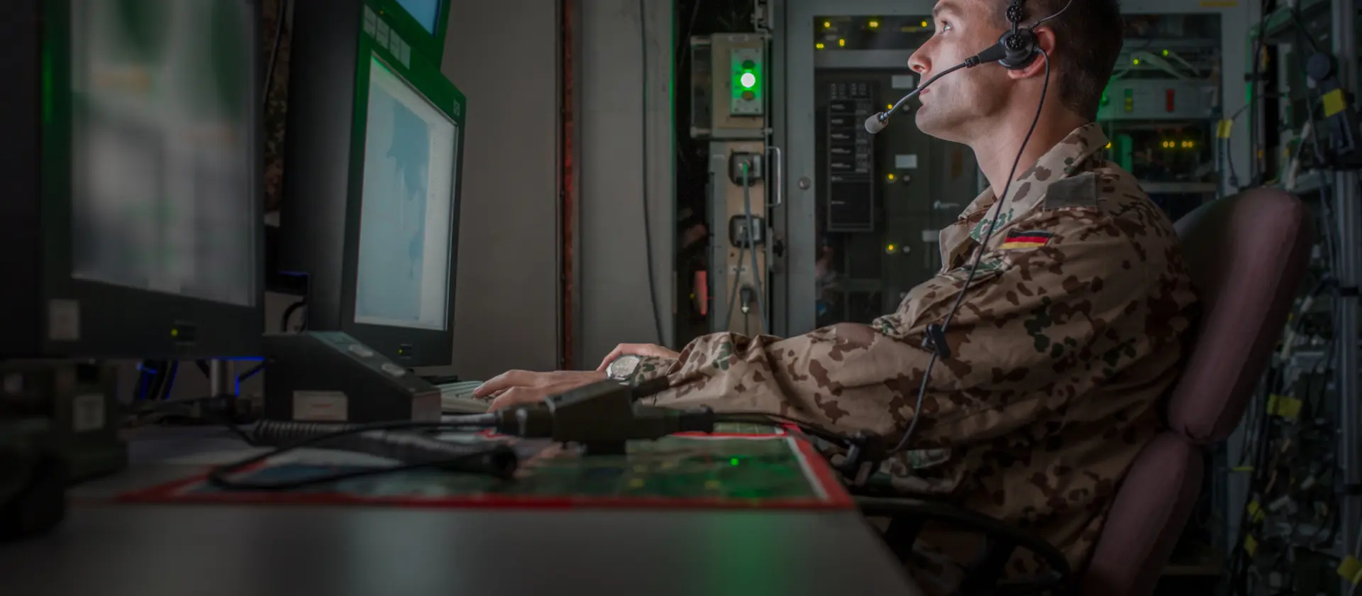 Bundeswehrsoldat mit Headset schaut auf einen Monitor