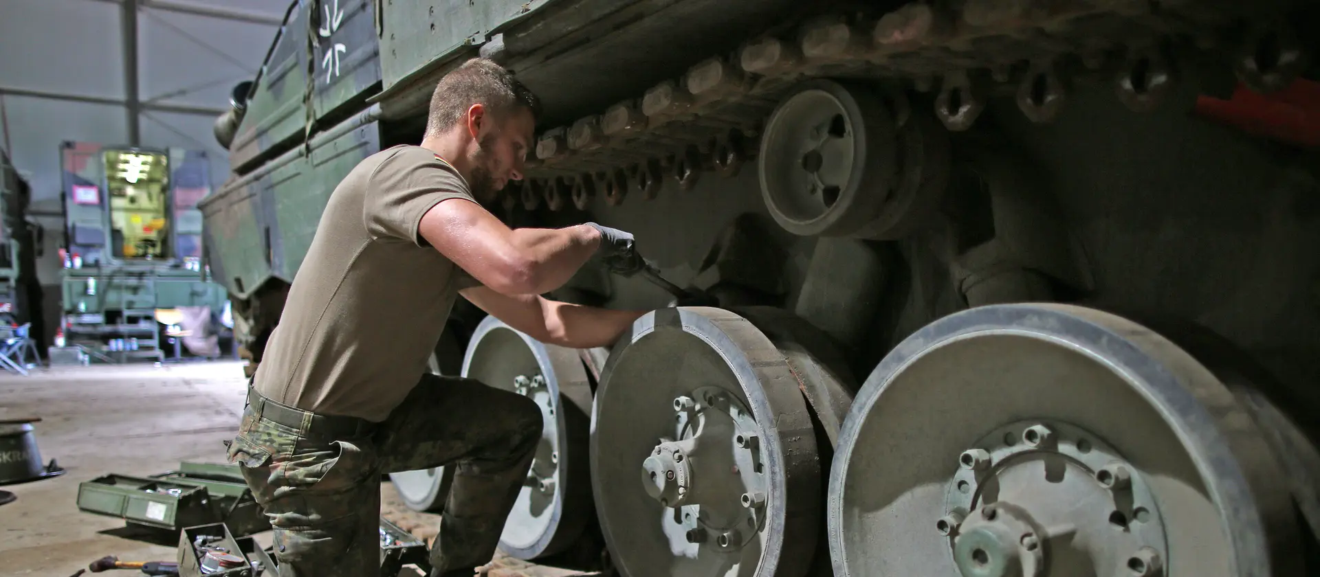 EIn Soldat arbeitet an der Panzerkette