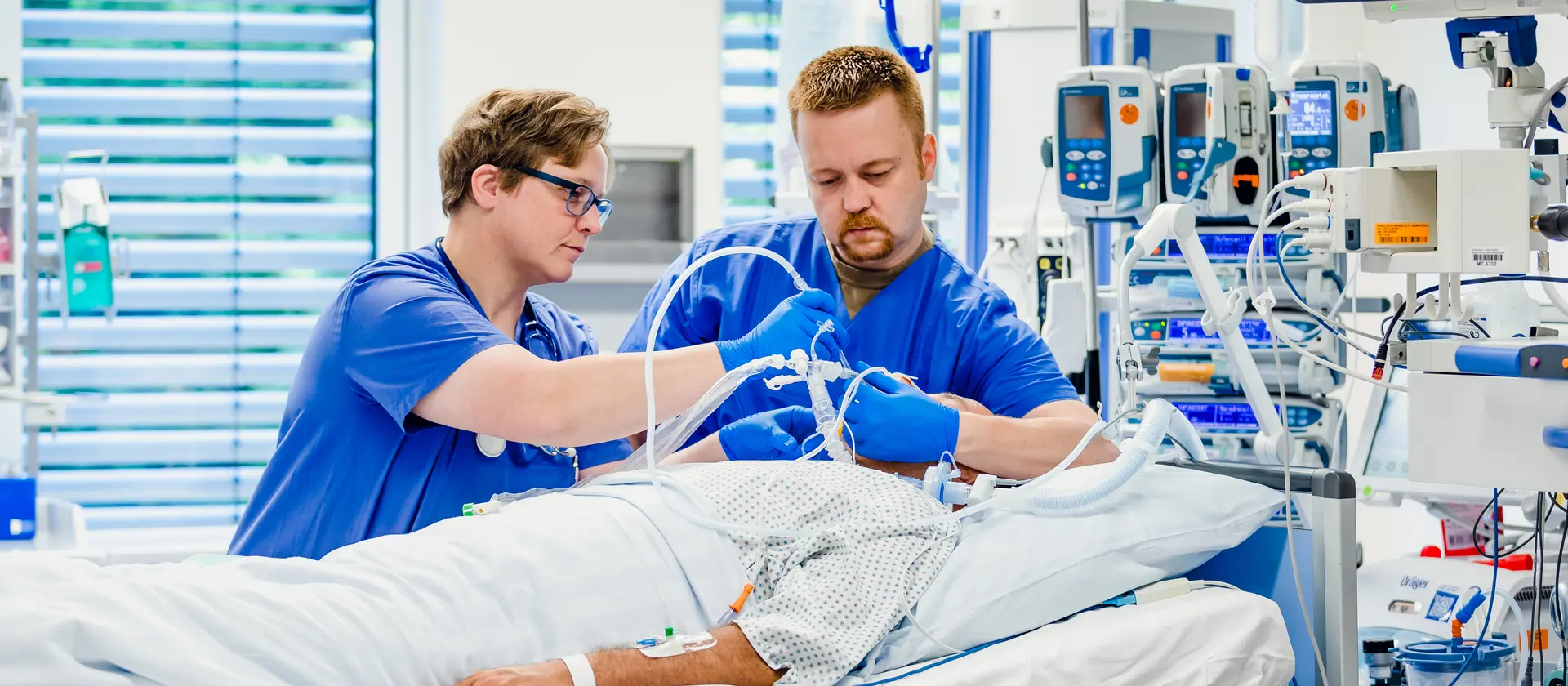 Zwei Fachkrankenpfleger betreuen einen Patienten