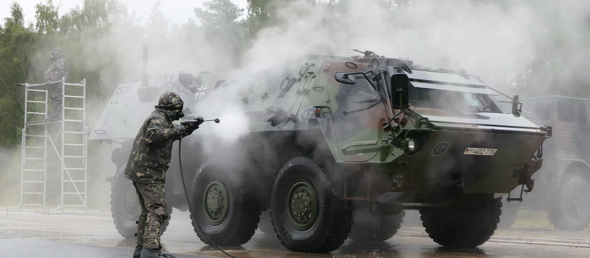 Ein Soldat der Bundeswehr reinigt ein Fahrzeug