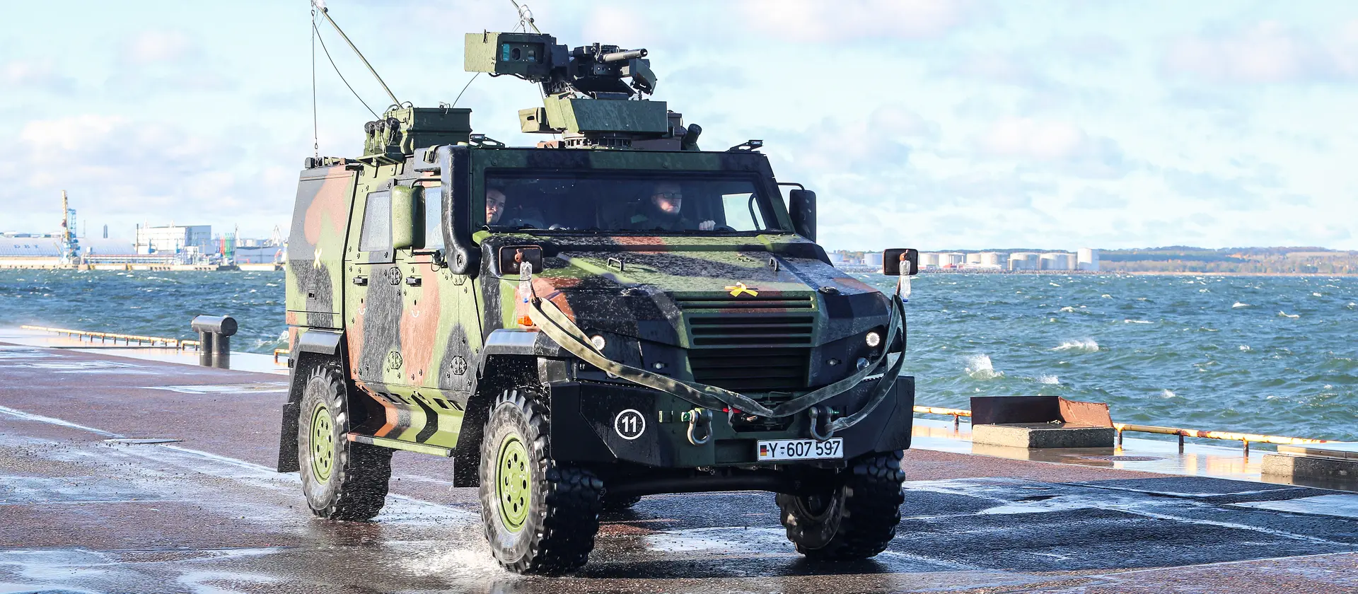 Zwei Soldaten in einem Bundeswehr-Fahrzeug, das auf einer Straße am Meer fährt